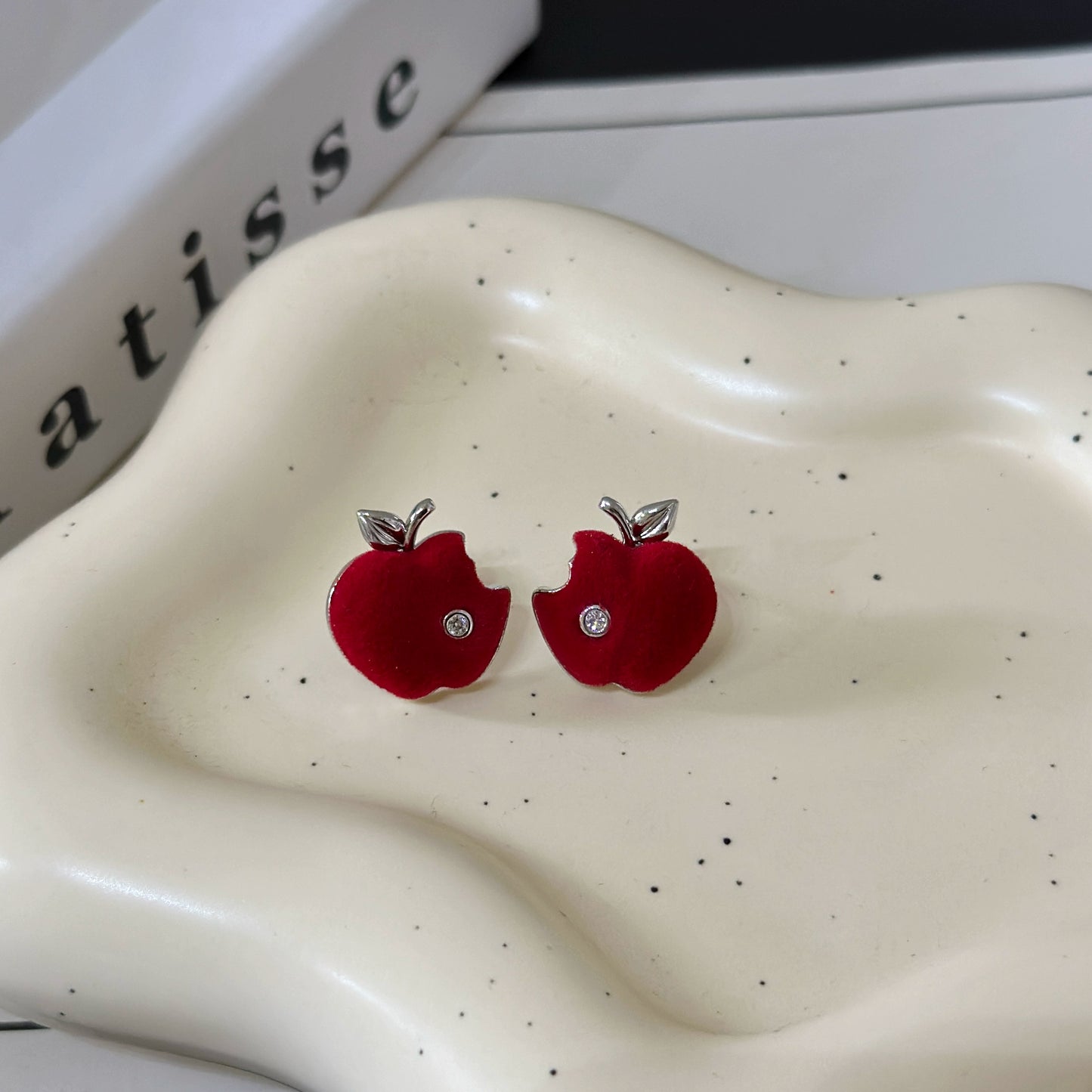 A necklace with apple earrings and ear clips