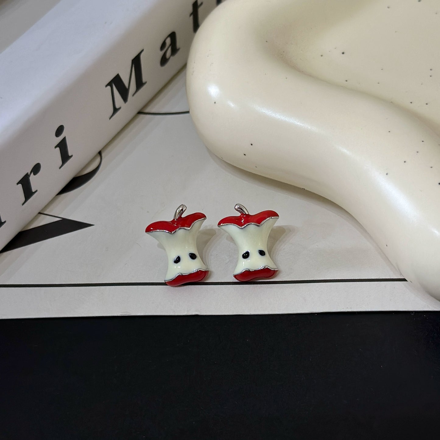 A necklace with apple earrings and ear clips