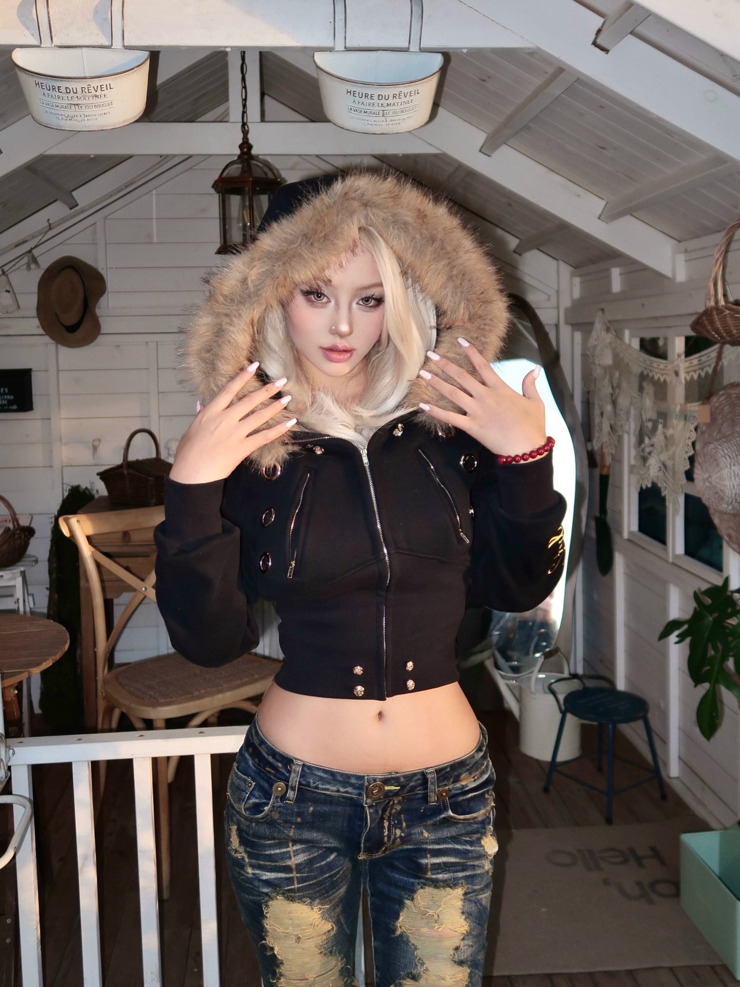 furry hooded sweatshirt and a black embroidered jacket