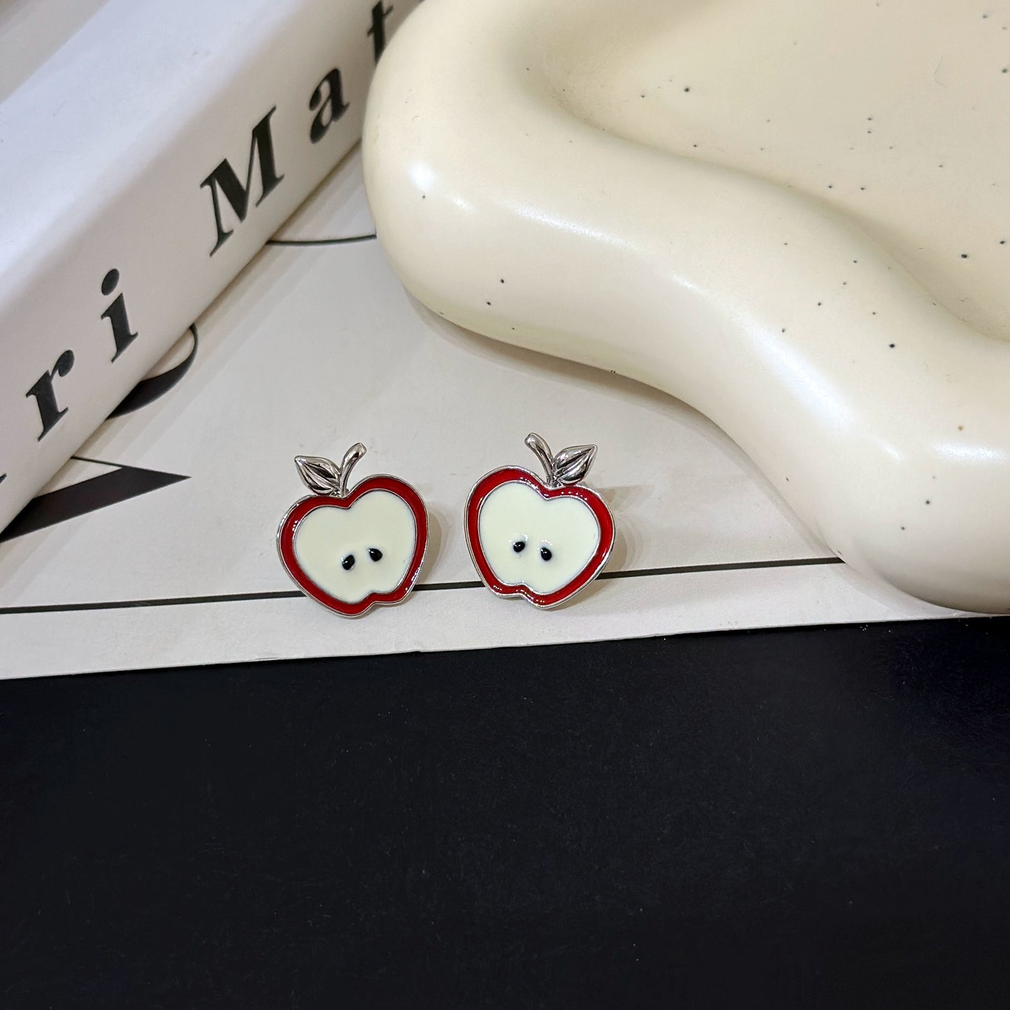 A necklace with apple earrings and ear clips